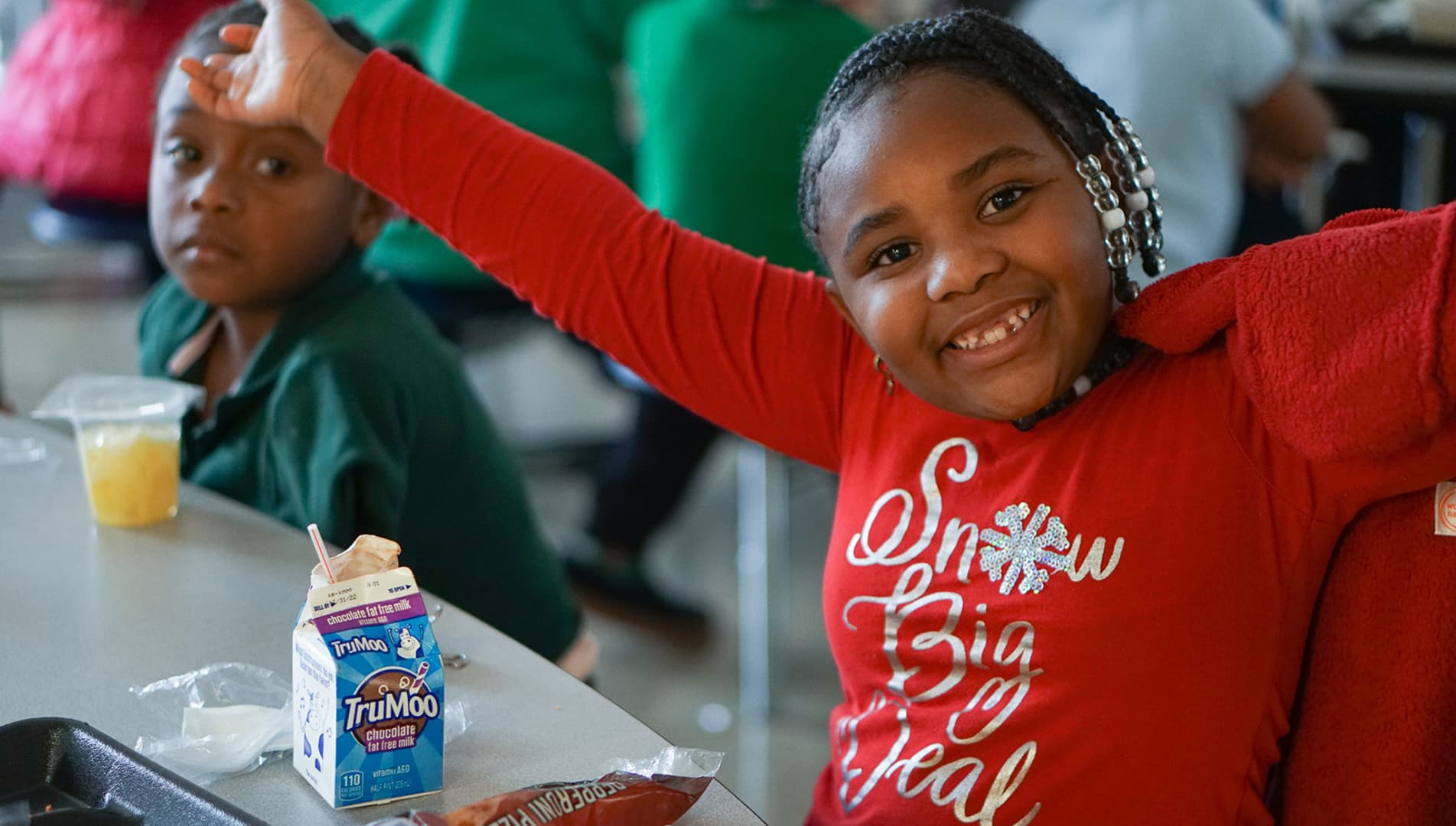 Smiling student celebrating with healthy Clark Foods Co. meal options